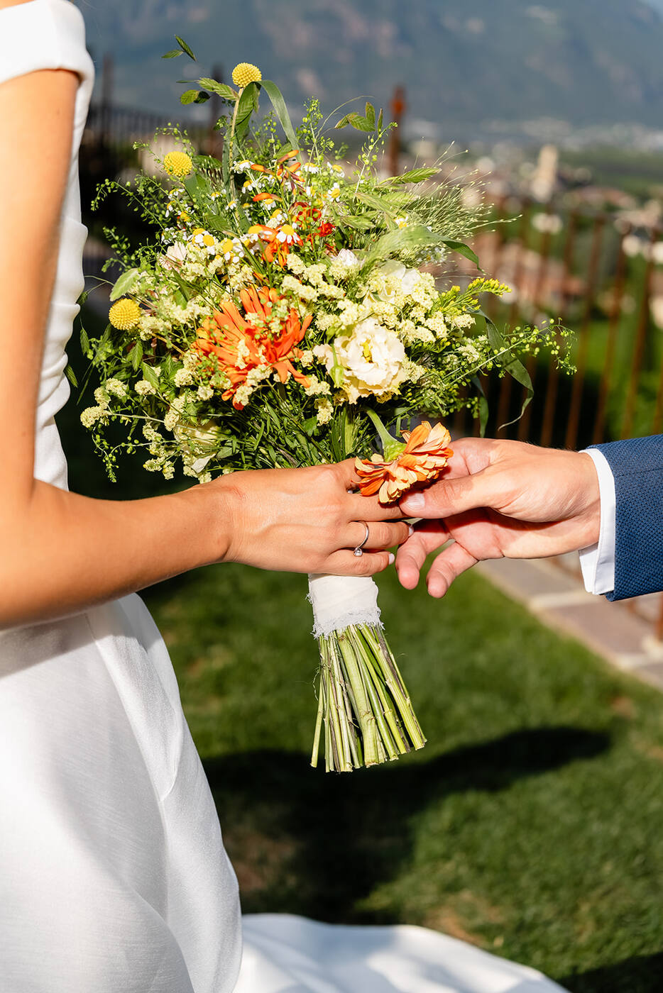 Le mani degli sposi e il bouquet